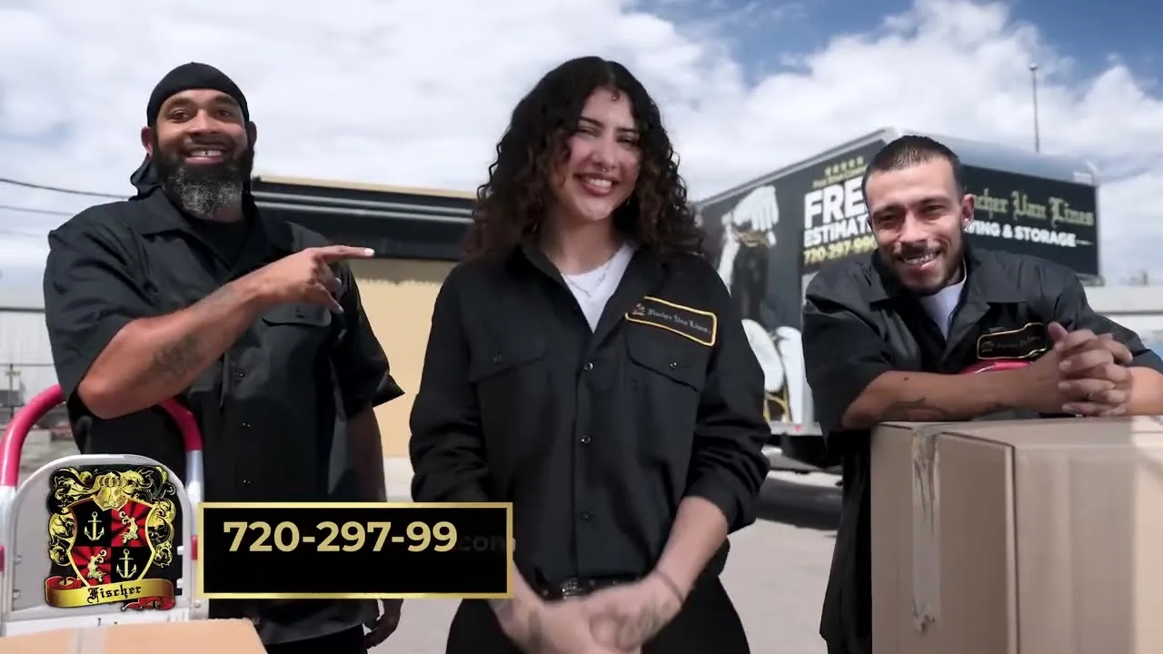 Three Fischer Van Lines crew members in branded uniforms standing beside a company moving truck in Denver